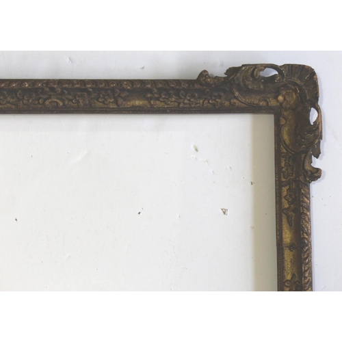 594 - A CARVED AND GILDED PICTURE FRAME the corners with pierced leafy scroll and shell decoration, floral... 