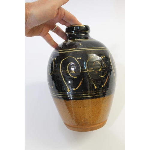 751 - ABUJA STUDIO POTTERY JUG with a tenmoku glaze and line decoration, seal mark to base of handle (diff... 