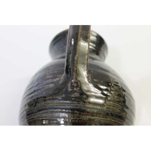 751 - ABUJA STUDIO POTTERY JUG with a tenmoku glaze and line decoration, seal mark to base of handle (diff... 