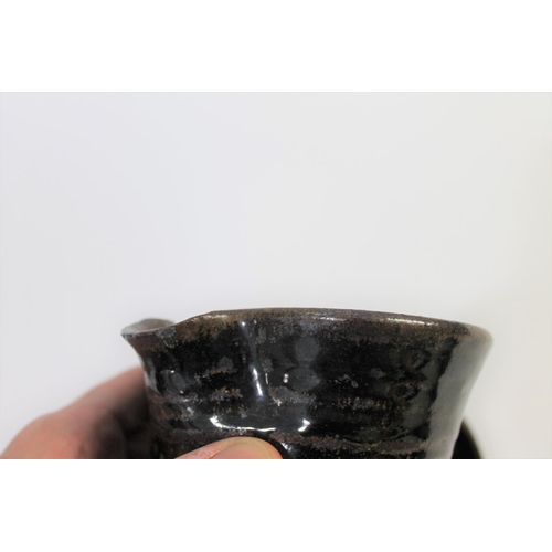 751 - ABUJA STUDIO POTTERY JUG with a tenmoku glaze and line decoration, seal mark to base of handle (diff... 