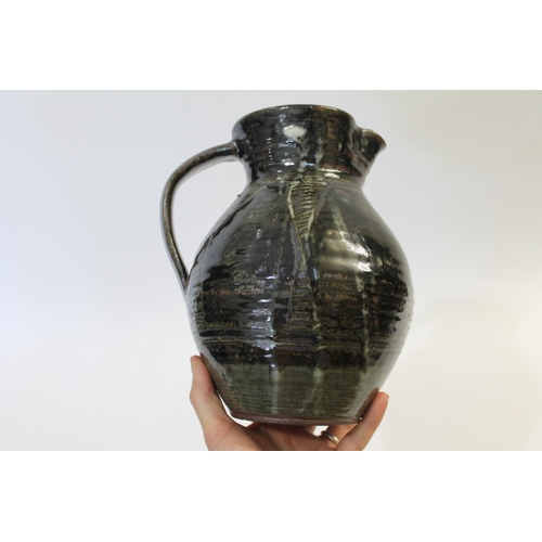 751 - ABUJA STUDIO POTTERY JUG with a tenmoku glaze and line decoration, seal mark to base of handle (diff... 