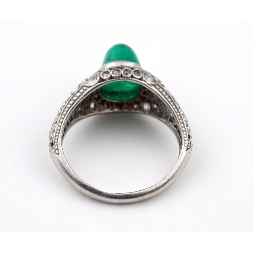 1177 - AN EMERALD & DIAMOND CLUSTER RING. the oval-shaped cabochon emerald is set within a surround of circ... 