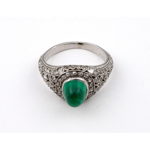 1177 - AN EMERALD & DIAMOND CLUSTER RING. the oval-shaped cabochon emerald is set within a surround of circ... 