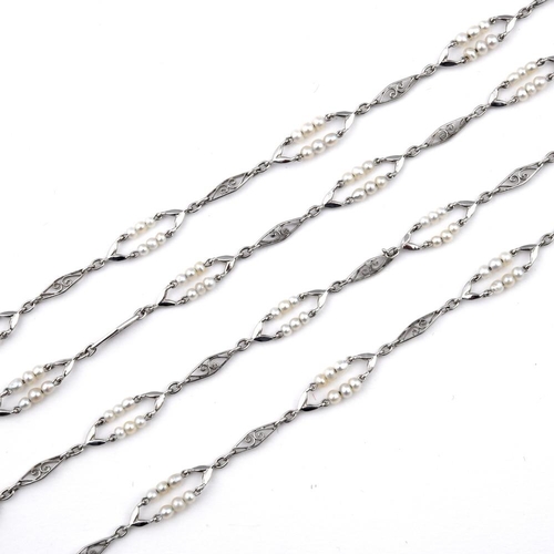 1183 - A PLATINUM AND PEARL SET LONG CHAIN NECKLACE. formed with alternate pearl set and openwork lozenge-s... 