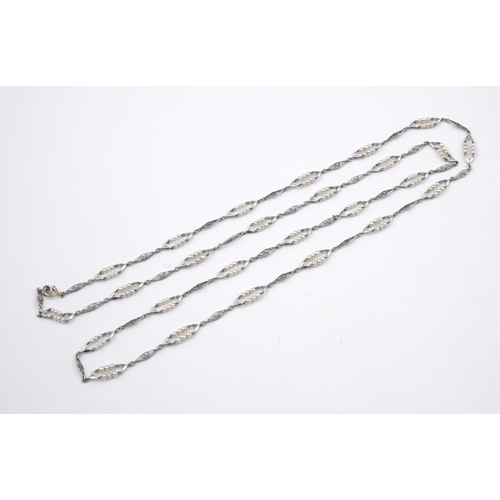 1183 - A PLATINUM AND PEARL SET LONG CHAIN NECKLACE. formed with alternate pearl set and openwork lozenge-s... 