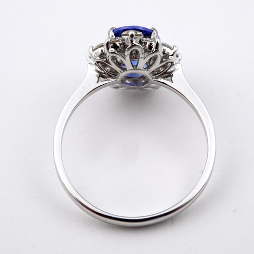 1187 - A TANZANITE AND DIAMOND CLUSTER RING. the oval-shaped tanzanite weighs 1.71 carats and is set within... 