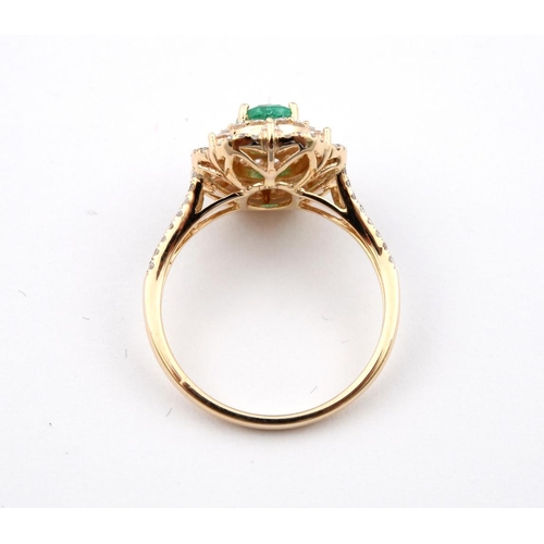 1188 - AN EMERALD AND DIAMOND CLUSTER RING. the oval-shaped emerald is set within a surround of round brill... 