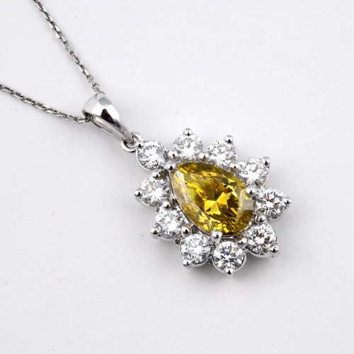 1190 - A FANCY YELLOW DIAMOND AND DIAMOND CLUSTER PENDANT. the pear-shaped fancy yellow diamond is set with... 