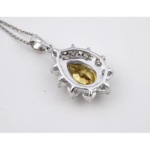 1190 - A FANCY YELLOW DIAMOND AND DIAMOND CLUSTER PENDANT. the pear-shaped fancy yellow diamond is set with... 