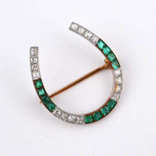 1192 - AN EMERALD & DIAMOND HORSESHOE BROOCH. mounted with cushion-shaped old cut diamonds and rectangular-... 