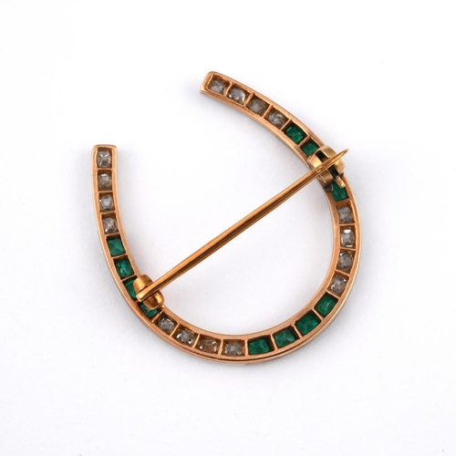 1192 - AN EMERALD & DIAMOND HORSESHOE BROOCH. mounted with cushion-shaped old cut diamonds and rectangular-... 