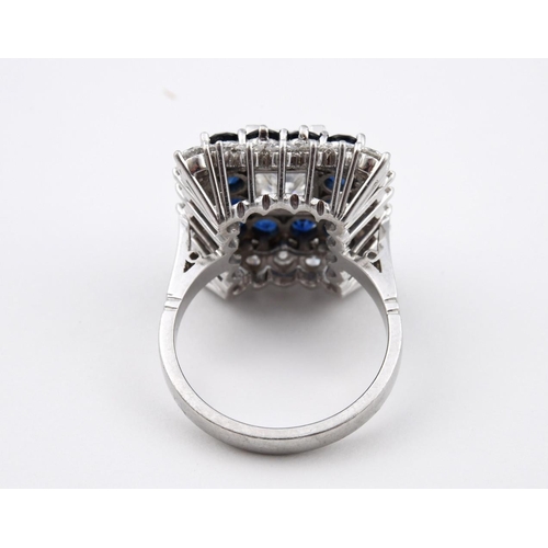 1195 - A SAPPHIRE AND DIAMOND CLUSTER RING. the rectangular step-cut diamond is set within a surround of ci... 