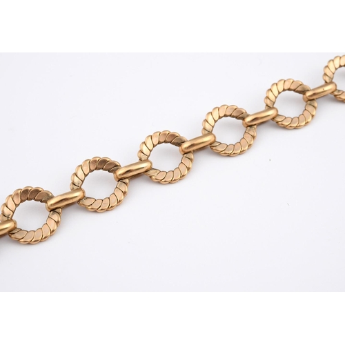 943 - A GOLD BRACELET. formed with circular engraved links, 22cm long, 32.7 grams.  **BP 22.5% inc VAT + L... 