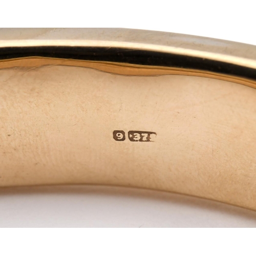 951 - A 9CT GOLD HALF HINGED BANGLE. with foliate engraved decoration to one side, internal measurements 6... 