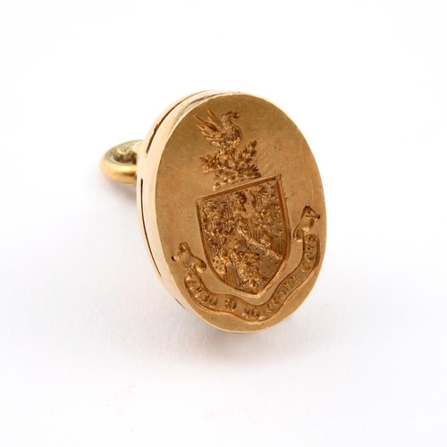 970 - AN 18CT GOLD SEAL. fluted body, the gold matrix engraved with a coat of arms, 2.5cm high, 14.3 grams... 