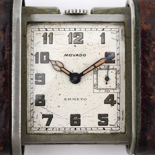 977 - A STAINLESS STEEL TRAVELLING CLOCK BY MOVADO. the square-shaped dial with Arabic numerals and subsid... 