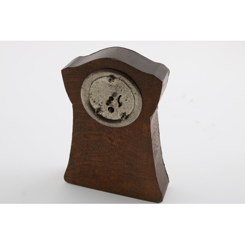 140 - AN ARTS AND CRAFTS MOUNTED WOODEN CLOCK. embossed with a ship at rough sea, 