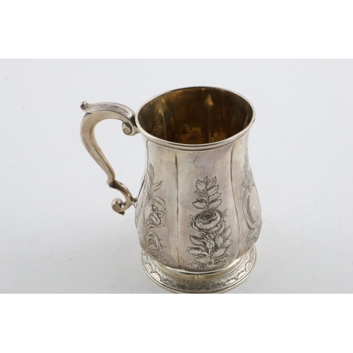 152 - A GEORGE II MUG. of lobed baluster form, with a scroll handle, later foliate decoration and a  circu... 