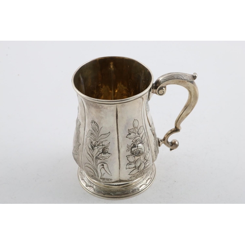 152 - A GEORGE II MUG. of lobed baluster form, with a scroll handle, later foliate decoration and a  circu... 