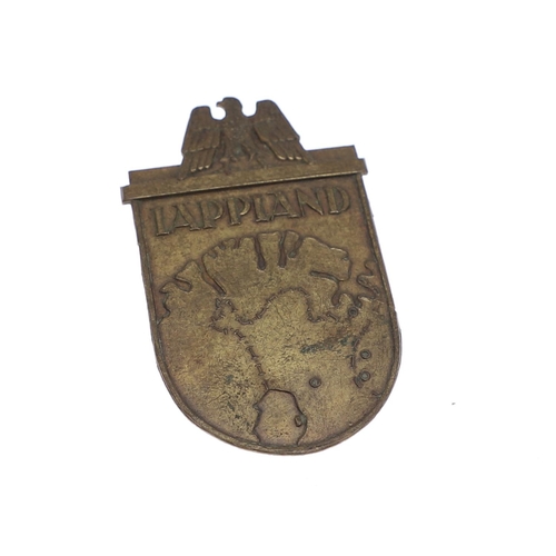 251 - A SECOND WORLD WAR GERMAN 'LAPPLAND' SHIELD. A bronze type Lappland badge with eagle above a low rel... 