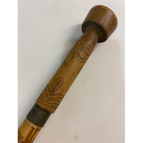 38 - AN AFRICAN BLOW PIPE OR DART GUN WITH DARTS. A long bamboo blow pipe with mouth piece and hand grip,... 