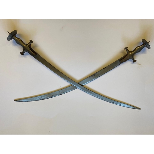 73 - A PAIR OF INDIAN 'TULWAR' TYPE SWORDS. A pair of swords with single edged 75cm blades, the handles w... 