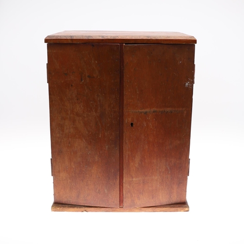 683 - AN EALY 20TH CENTURY STAINED PINE COIN COLLECTORS CABINET. A two door cabinet containing fifteen tra... 