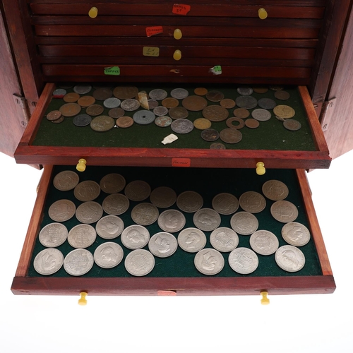 683 - AN EALY 20TH CENTURY STAINED PINE COIN COLLECTORS CABINET. A two door cabinet containing fifteen tra... 