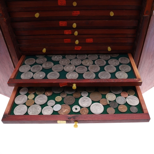 683 - AN EALY 20TH CENTURY STAINED PINE COIN COLLECTORS CABINET. A two door cabinet containing fifteen tra... 