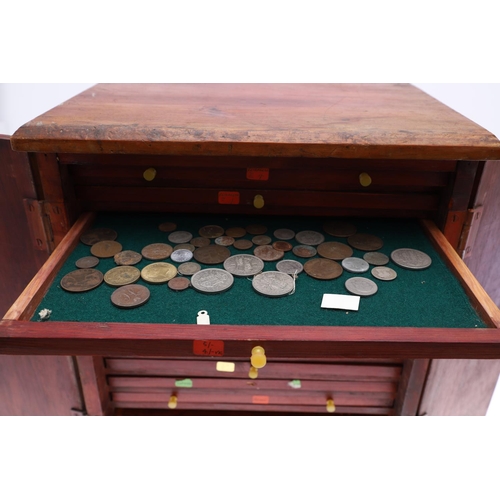 683 - AN EALY 20TH CENTURY STAINED PINE COIN COLLECTORS CABINET. A two door cabinet containing fifteen tra... 