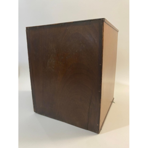 687 - AN EARLY 20TH CENTURY MAHOGANY COIN CABINET. A single door coin cabinet with strung edges, the inter... 