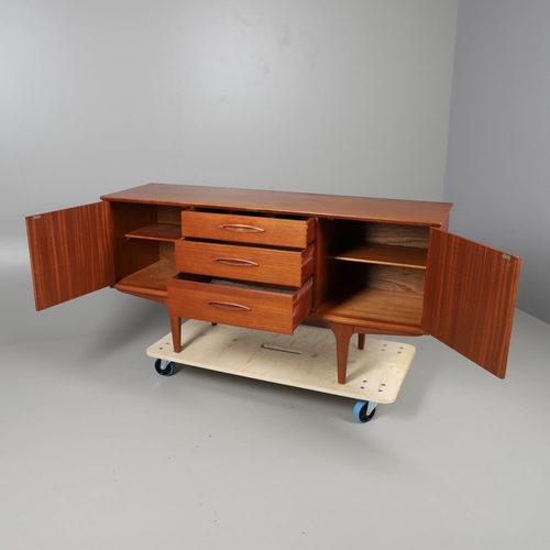 672 - A MID CENTURY TEAK SIDEBOARD. The sideboard with three central drawers flanked by cupboards, and sup... 