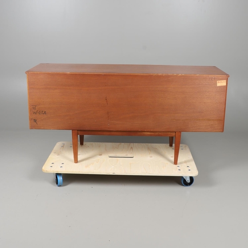 672 - A MID CENTURY TEAK SIDEBOARD. The sideboard with three central drawers flanked by cupboards, and sup... 