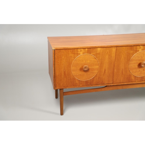 684 - MID CENTURY TEAK SIDEBOARD. A large sideboard with two cupboard doors with circular panels and inter... 