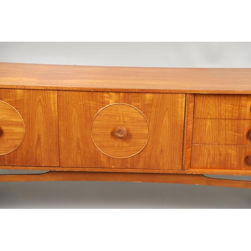 684 - MID CENTURY TEAK SIDEBOARD. A large sideboard with two cupboard doors with circular panels and inter... 