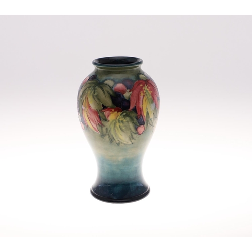 694 - MOORCROFT VASE - LEAF & BERRY. An early Moorcroft vase in the Leaf and Berry design on green and blu... 