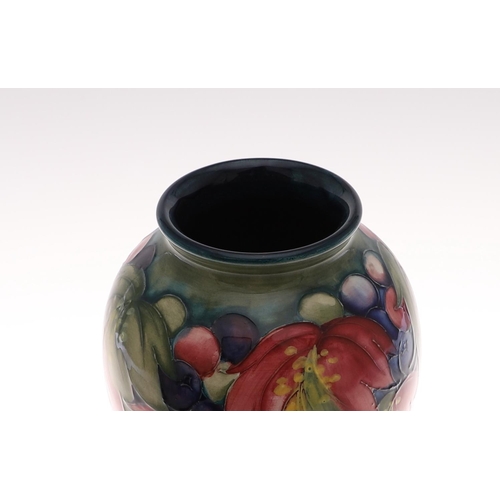 694 - MOORCROFT VASE - LEAF & BERRY. An early Moorcroft vase in the Leaf and Berry design on green and blu... 