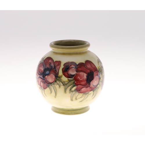 695 - ANTIQUE MOORCROFT ANEMONE VASE. A globular vase painted in the Anemone design on an unusual pale gre... 