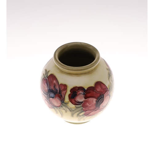 695 - ANTIQUE MOORCROFT ANEMONE VASE. A globular vase painted in the Anemone design on an unusual pale gre... 