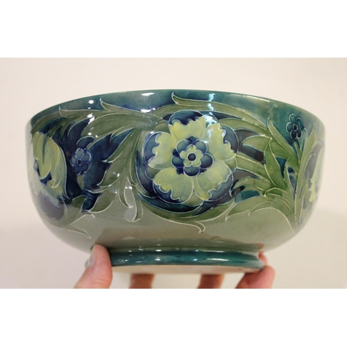 696 - ANTIQUE MOORCROFT BOWL - LATE FLORIAN. A large bowl painted with flowers and leaves on a blue and gr... 