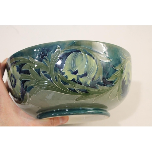 696 - ANTIQUE MOORCROFT BOWL - LATE FLORIAN. A large bowl painted with flowers and leaves on a blue and gr... 