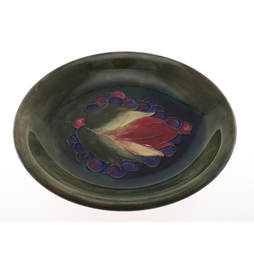 697 - ANTIQUE MOORCROFT PLATE - LEAF & BERRY, ORIGINAL PAPER LABEL. The plate painted in the centre with a... 