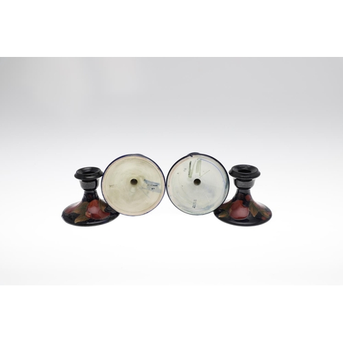 721 - TWO PAIRS OF ANTIQUE MOORCROFT CANDLESTICKS - POMEGRANATE. Including a small pair of candlesticks, p... 