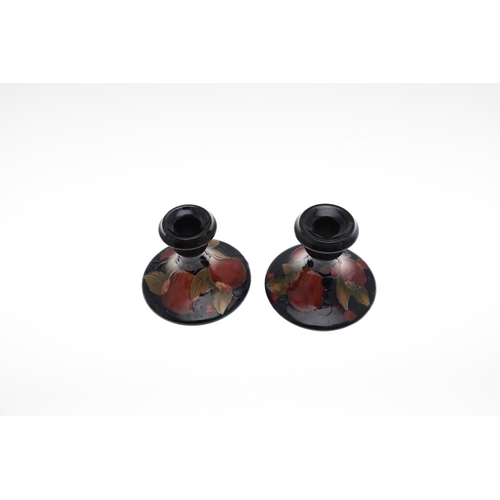 721 - TWO PAIRS OF ANTIQUE MOORCROFT CANDLESTICKS - POMEGRANATE. Including a small pair of candlesticks, p... 