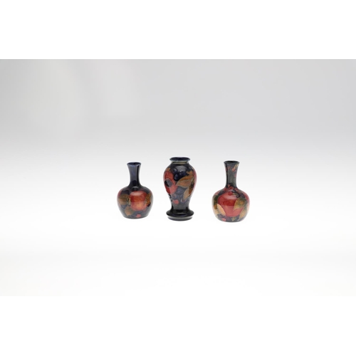 722 - MOORCROFT MINIATURE VASES - POMEGRANATE. Including a miniature baluster shaped vase painted in the P... 