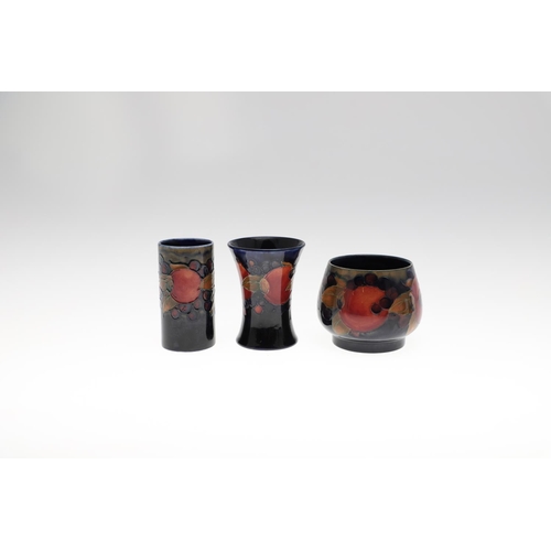 735 - ANTIQUE MOORCROFT ITEMS - POMEGRANATE. A mixed lot including a small slender vase (8.5cms high), a c... 