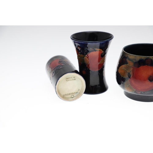 735 - ANTIQUE MOORCROFT ITEMS - POMEGRANATE. A mixed lot including a small slender vase (8.5cms high), a c... 