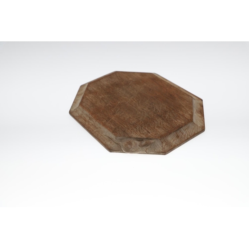 743 - ROBERT THOMPSON OF KILBURN - MOUSEMAN CHEESE BOARD. An oak octagonal shaped cheese board, with carve... 