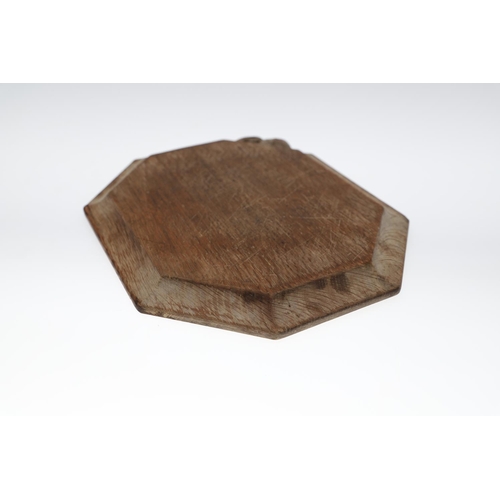 743 - ROBERT THOMPSON OF KILBURN - MOUSEMAN CHEESE BOARD. An oak octagonal shaped cheese board, with carve... 