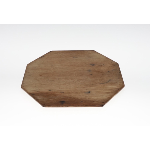 743 - ROBERT THOMPSON OF KILBURN - MOUSEMAN CHEESE BOARD. An oak octagonal shaped cheese board, with carve... 